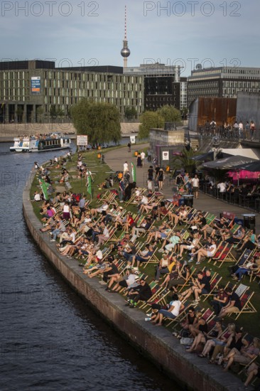 DEU Germany Germany Berlin In summer temperatures, people sit on the Spreebogen and enjoy the warmth