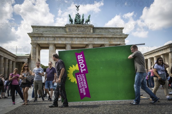 DEU Germany Germany Berlin Two men carry a Green Party billboard across Pariser Platz. After a press conference in front of the Brandenburg Tor, where the campaign tour was explained, they load the paraphernalia for removal