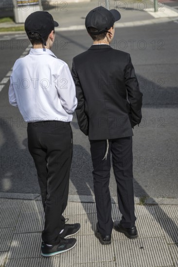 DEU Germany Germany Berlin Two boys in suits with baseball caps at a pedestrian crossing