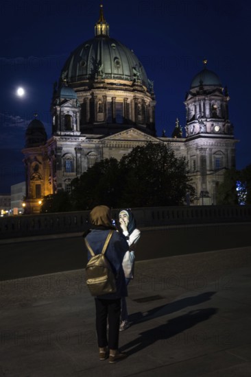 DEU Germany Germany Berlin Women photographing themselves in front of Berlin Cathedral with the moon at the blue hour