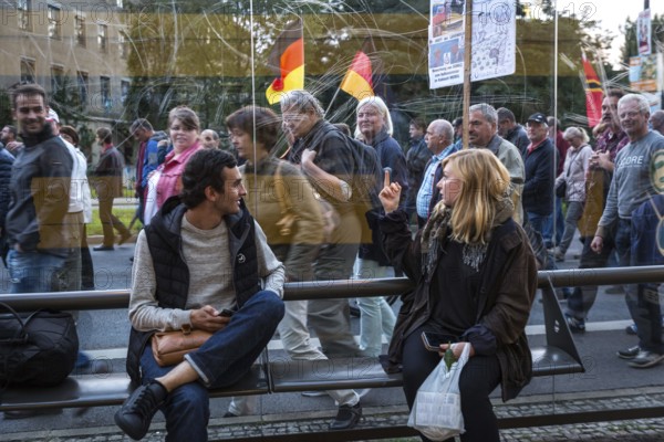 DEU Germany Germany Dresden Pegida demonstration in the city centre.woman of the demonstration shows the middle finger to a woman at a tram stop