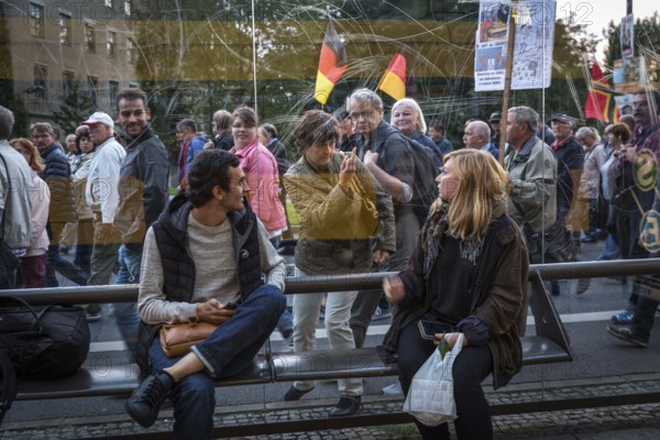 DEU Germany Germany Dresden Pegida demonstration in the city centre.woman of the demonstration shows the middle finger to a woman at a tram stop