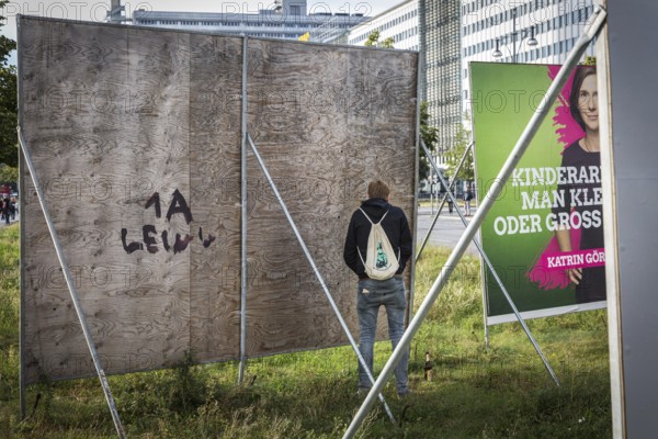 DEU Germany Germany Berlin Demonstration 'Who owns the city' by music fans and club goers through Berlin-Mitte. A man pees behind an election poster