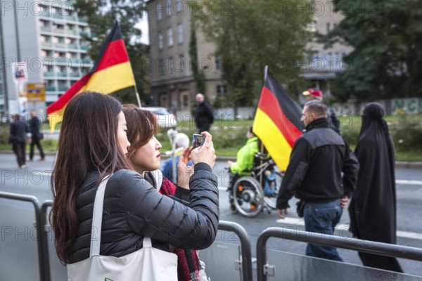 DEU Germany Germany Dresden Pegida demonstration in the city centre. Asian tourists take a photo of a veiled woman