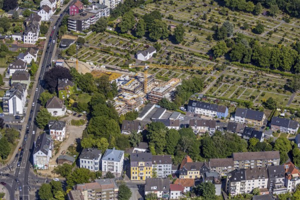 Aerial view, construction site new residential buildings, former Opel car dealership Brinkmann site, Bredenscheider Straße, Evang. Cemetery at the water tower, Hattingen, Ruhr area, North Rhine-Westphalia, Germany, construction area, building site, building plots, building crane, construction project, construction site, burial site, DE, Ennepe-Ruhr district, Europe, cemetery, memorial, place of worship, graves, burial ground, capacity requirement, aerial photograph, aerial photography, aerial photography, new building, resting place, overview, bird's-eye view, living and life, birds-eyes view, overview
