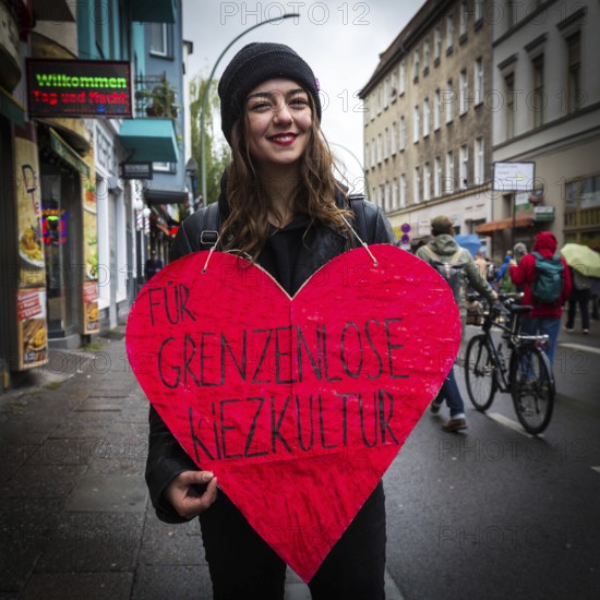 DEU Germany Germany Berlin Demonstration against rent increases and gentrification.woman demonstrates with heart for borderless neighbourhood culture