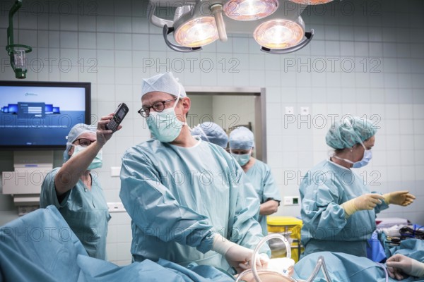 DEU Germany Germany Wittenberg Everyday life at the Paul Gerhardt Stift Protestant hospital in Luther city Wittenberg, an operation situation in which the head physician is talking on a telephone held by an assistant at the same time