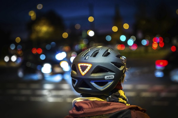 DEU Germany Germany Berlin A cyclist wearing a helmet with LED light waits at a traffic light on Potsdamer Straße