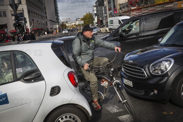DEU Germany Germany Berlin Cyclists squeeze between stationary cars on Potsdamer Platz