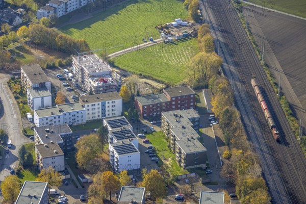 Aerial view, residential buildings construction site Röntgenstraße, Pelkum, Hamm, Ruhr area, North Rhine-Westphalia, Germany, railway tracks, construction work, building, construction area, building site, building plots, construction project, construction site, DE, Europe, shapes and colours, property tax, goods train, high-rise buildings, real estate, aerial view, aerial photography, aerial photography, multi-family houses, new building, photovoltaic, photovoltaic system, solar, solar system, solar energy, solar energy, overview, bird's-eye view, housing estate, housing and living, residential area, residential buildings, housing quality, housing estate, birds-eyes view, overview