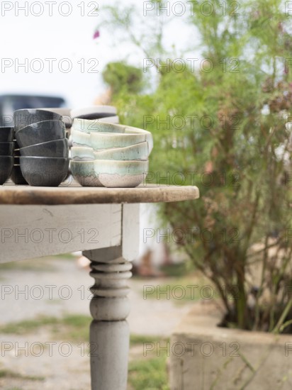 Artisan crafted ceramic bowls arranged on a vintage wooden table at an outdoor market