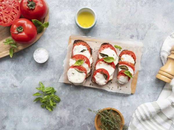 Caprese bruschetta with fresh ingredients on a light gray background, ready to eat