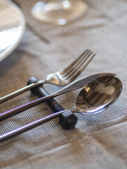 Utensils elegantly resting on an industrial bolt creating a unique table setting