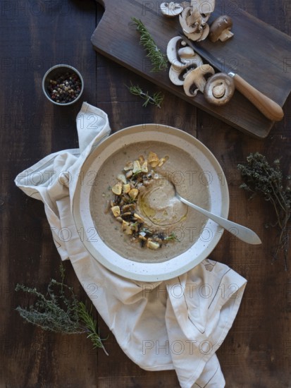 Hearty mushroom soup garnished with savory herbs and crunchy croutons on a rustic wooden table