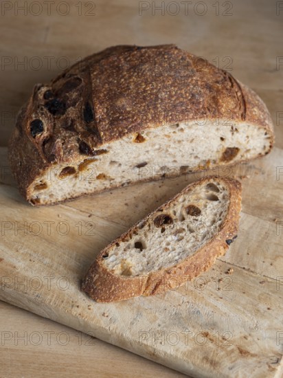 Freshly baked sourdough bread with raisins on a rustic cutting board