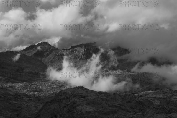 View over the Steinernes Meer Plateau to the summit of the Funtenseetauern with moving clouds, monochrome, Berchtesgaden Alps, between Bavaria and Austria