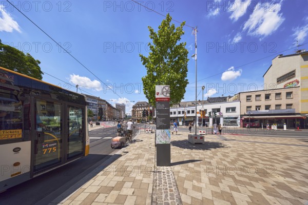 Public bus, public transport, concrete paving walkway, traffic area, street, square, general architecture, commercial building, residential building, tram tracks, bench, tree, bicycle, stele with location sign, cyclists and pedestrians as a secondary motif, blue sky, cumulus clouds, Schillerstraße, Große Bleiche and Münsterplatz intersection, Mainz, state capital, district-free city, Rhineland-Palatinate, Germany