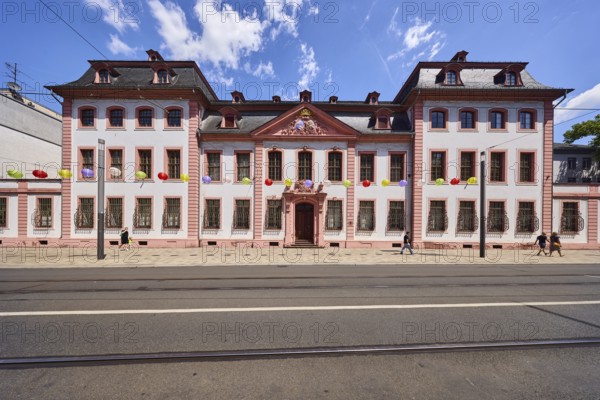 Erthaler Hof, Adelshof, architectural style classicism, façade with windows and door, historic building, lantern, tram tracks, asphalt road, decoration, lanterns, pedestrians as accessories, blue sky, cumulus clouds, Schillerstraße street, Mainz, state capital, district-free city, Rhineland-Palatinate, Germany