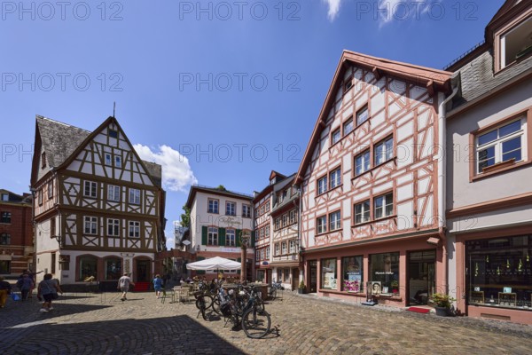 Historic half-timbered houses, general architecture, buildings, paving stone square, bicycles, outdoor area of a restaurant, pedestrians as a secondary motif, blue sky, cumulus clouds, Hollagäßchen, Kirschgarten, Mainz, state capital, district-free city, Rhineland-Palatinate, Germany