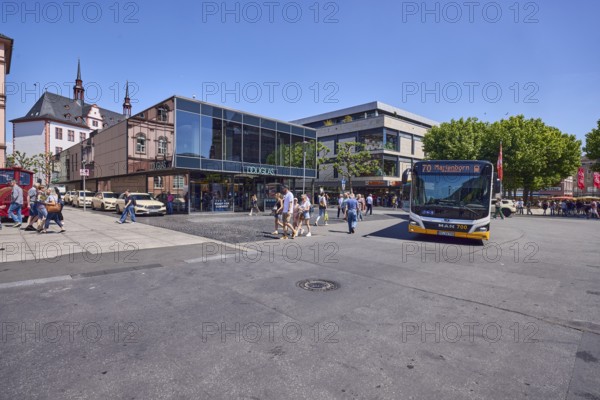 Commercial building, general architecture, modern building, perfumery, Douglas, public bus, bus line 70 Marienborn, pedestrians as accessories, trees, blue sky, cloudless, intersection of Gutenbergplatz with Schöfferstraße and Höfchen, Mainz, state capital, district-free city, Rhineland-Palatinate, Germany
