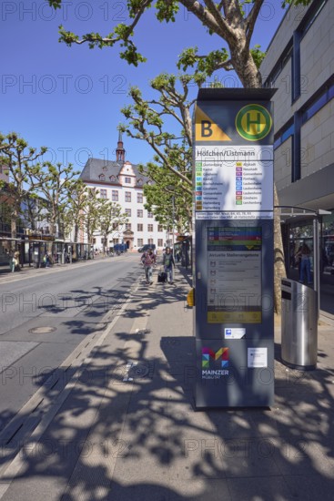 Mainz Höfchen Listmann bus stop, bus platform B, commercial building, general architecture, trees, common plane tree (Platanus ×hispanica), pedestrians as accessories, people waiting for means of transport, blue sky, cloudless, Schöfferstraße, Mainz, state capital, district-free city, Rhineland-Palatinate, Germany