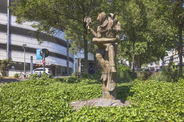 Till Eulenspiegel statue, sculptor Eberhard Linke, Kronberger Hof car park, trees, ground cover, common ivy (Hedera helix), sunny, street Am Kronberger Hof, Mainz, state capital, district-free city, Rhineland-Palatinate, Germany