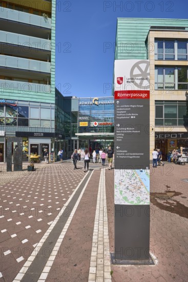 Stele with location sign, Roman passage, shopping center, general architecture, modern building, commercial building, shop, retail, sidewalk made of concrete paving stones and paving stones with pattern, pedestrian zone, trees, blue sky, cloudless, Cardinal-Volk-Platz, Mainz, state capital, district-free city, Rhineland-Palatinate, Germany