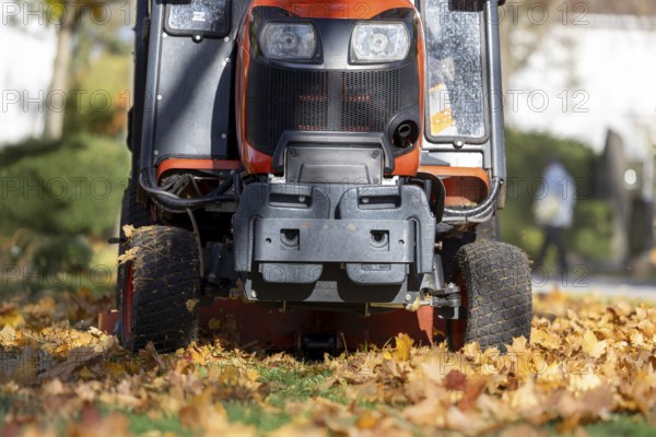 Removing leaves with a riding mower in a public park, Mutterstadt, Rheinland Pfalz