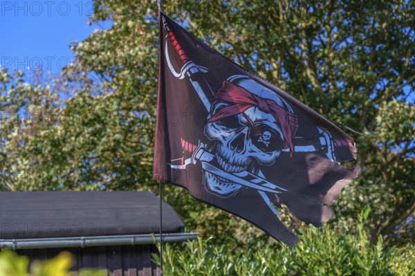 Pirate flag in a garden, Ahrenshoop, Darß, Mecklenburg-Western Pomerania, Germany