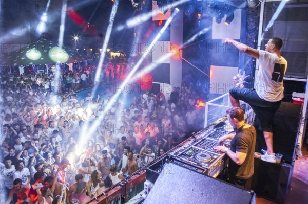 EDITORIAL and NEWS ONLY, rare moment of joint DJ back to back performance of edm dance music DJ Afrojack (on top, the person standing up on DJ pult) performing with DJ Hardwell on DJ pult at Starbeach events festival Hersonissos, Crete, Greece, on 17. July 2017. light show, dance music, crowd, stage performance