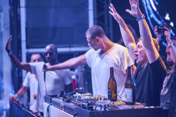 EDITORIAL and NEWS ONLY, rare moment of joint DJ back to back performance of edm dance music DJ Afrojack (person giving the microphone) performing with DJ Hardwell (the person at DJ pult with the hands raised) on DJ pult at Starbeach events festival Hersonissos, Crete, Greece, on 17. July 2017