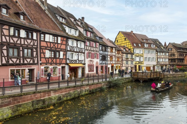 Traditional houses along a river here called the little Venice, with tourists visiting Colmar on a boat, Alsace, France