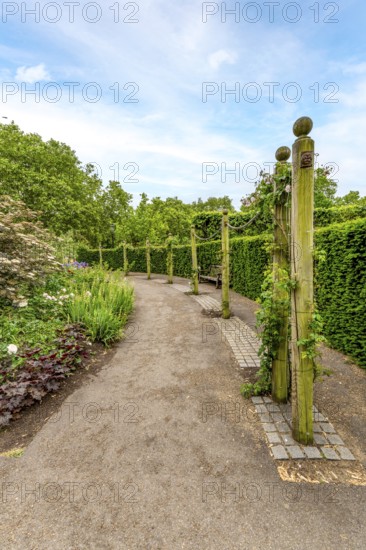 Elegant garden architecture: weathered wooden posts and chains bordering the walking trail at Hyde Park, London