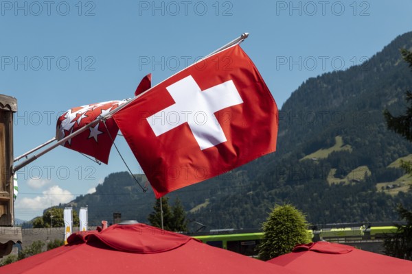 A flag of Switzerland pictured in Champery, a village by the French border with mountains at the background