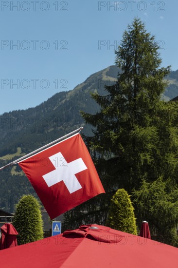 A flag of Switzerland pictured in Champery, a village by the French border with mountains at the background
