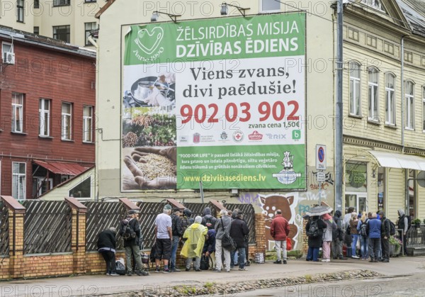 People queue at a soup kitchen, Krisjana Barona iela, Riga, Latvia