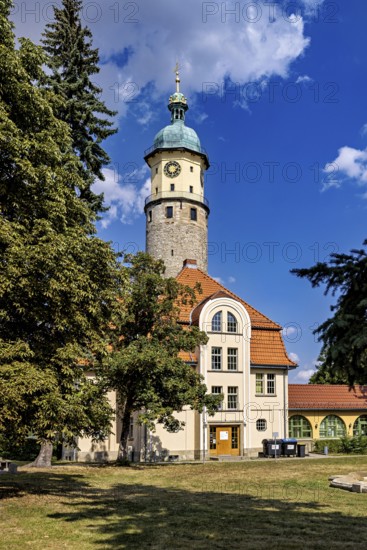 Tower with clock and building in the foreground, surrounded by trees under a blue sky, The Niedeck Ruin in Arnstadt Thuringia