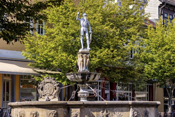 Fountain with an impressive warrior statue in a municipal park with trees, statue and memorial in the old town of Arnstadt in Thuringia