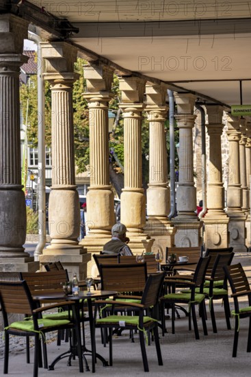 Historic outdoor café under pillars with green chairs and a quiet atmosphere in the city, arcades on the market square of Arnstadt in Thuringia
