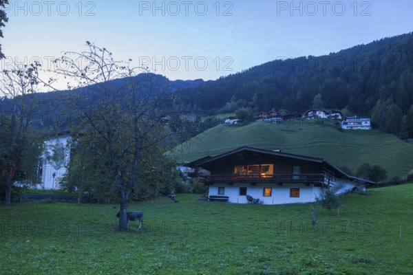 Houses, meadow and mountains with holiday home at dusk, Neustift im Stubai Valley, Stubai Valley, Stubai, Tyrol, Austria