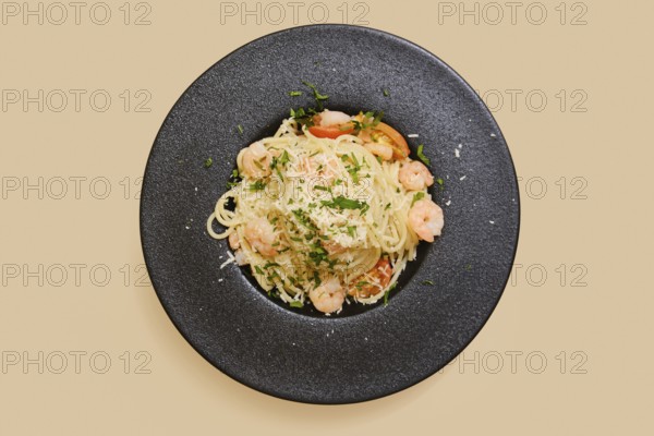 Delicious creamy garlic shrimp pasta in a black plate, garnished with herbs and cheese. This colorful dish showcases succulent shrimp and perfectly cooked pasta, ideal for dinner
