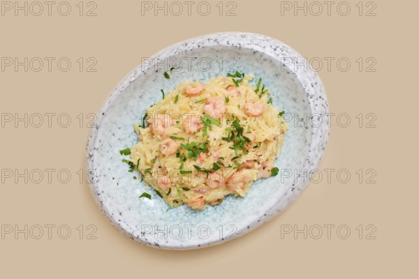 A delightful dish features risoni pasta mixed with tender shrimp and sprinkled with fresh herbs. This meal is perfect for a comforting lunch or dinner, showcasing simplicity and flavor