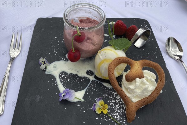 Dessert sweet dish cherry mousse with vanilla ice cream and heart-shaped pastry, international