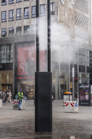 Digital water feature, Blue Cloud water installation on Husemanplatz in downtown Bochum, water mist is sprayed from 4 metal masts, which, in conjunction with the circular water surface, is intended to cool the surrounding area when it is hot, colored light images are projected into the water mist via projectors, part of the transformation of Husemanplatz