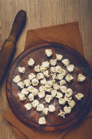 Traditional Turkish dumplings, raw, on a cutting board, top view, no people