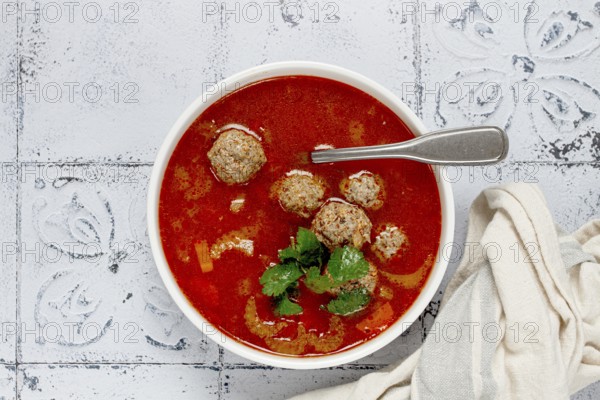 Romanian soup with meatballs, vegetable soup with meatballs, tiled table, homemade, no people
