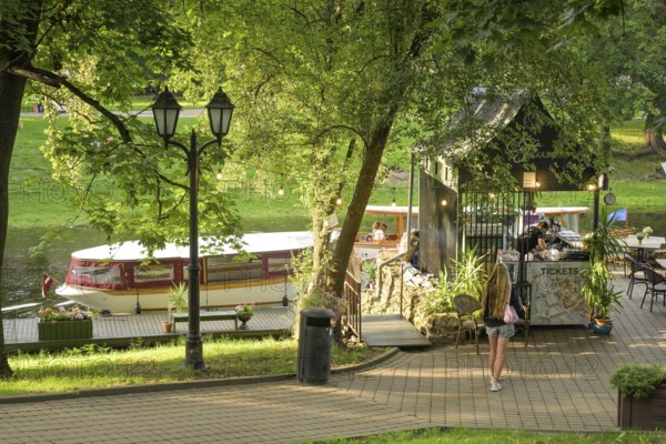 People, leisure, sightseeing boat, city canal, municipal park, Riga, Latvia