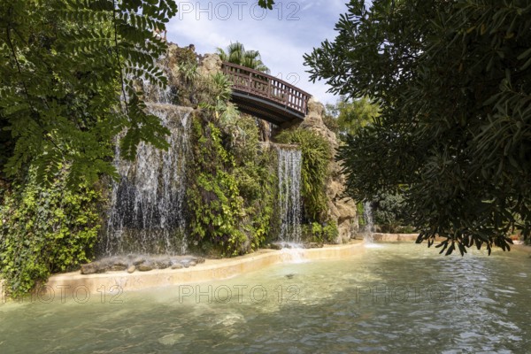 Beautiful natural park, with a bridge over waterfalls The Ornamental Pond in Genovés Botanic Gardens Cadiz, Andalusia Spain
