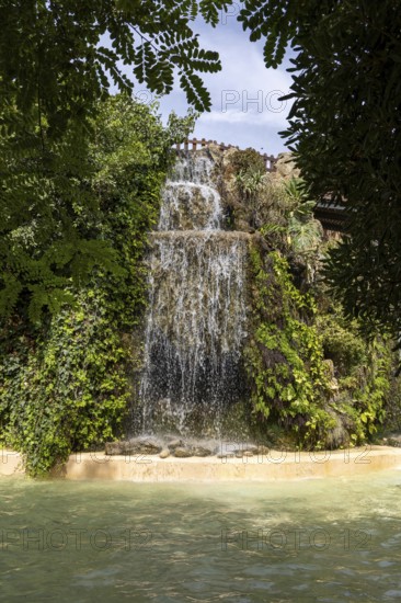 Beautiful natural park with a wide multi-tiered waterfall, The Ornamental Pond in Genovés Botanic Gardens Cadiz, Andalusia Spain