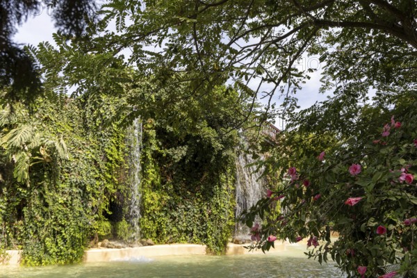 Beautiful natural park, with waterfalls and hibiscus blossoms The Ornamental Pond in Genovés Botanic Gardens Cadiz, Andalusia Spain